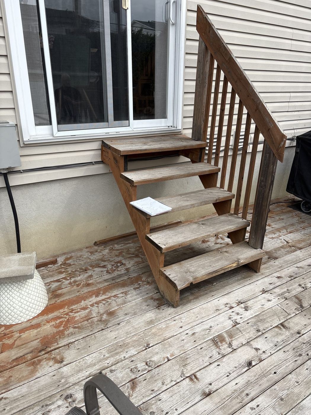 Weathered grey deck stairs and railing before rebuild